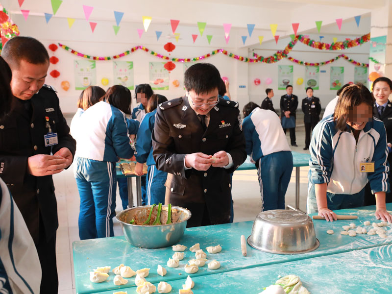 （用）省司法廳戒毒管理局局長段劍平（中）同干警、戒毒學(xué)員一起包餃子,。