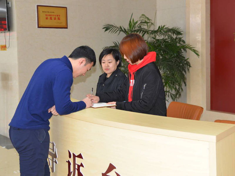 圖二,，記者和導(dǎo)訴臺(tái)工作人員一起指引市民查詢信息