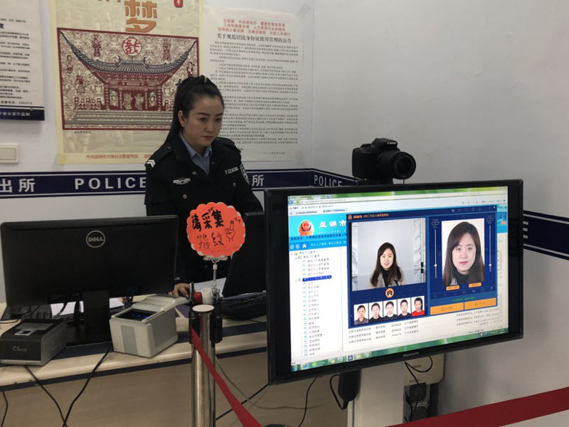 圖六 戶籍大廳中,，民警向記者展示最新的證件照拍攝方式