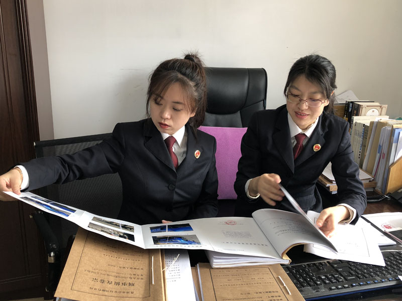 圖一：陳月（右一）告訴記者（左一）如何審查,、分析案卷,。