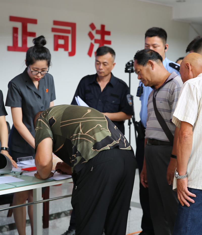 農(nóng)民工們正在東洲區(qū)法院法官干警的有序指導(dǎo)下領(lǐng)回自己的血汗錢