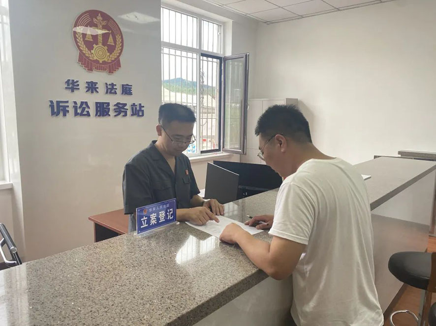 華來人民法庭訴訟服務(wù)站的工作人員指導(dǎo)當(dāng)事人寫起訴狀,。