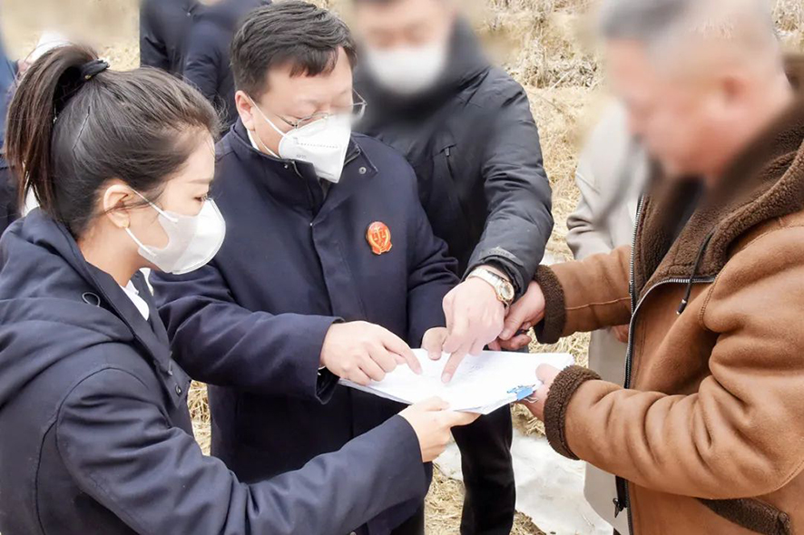 新民市法院大民屯法庭庭長王旌棘（左二）與委托代理人,、村委會(huì)干部核對土地面積——馬震宇攝