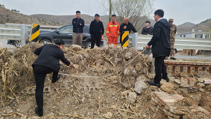 執(zhí)行干警現(xiàn)場丈量石墻占道面積。