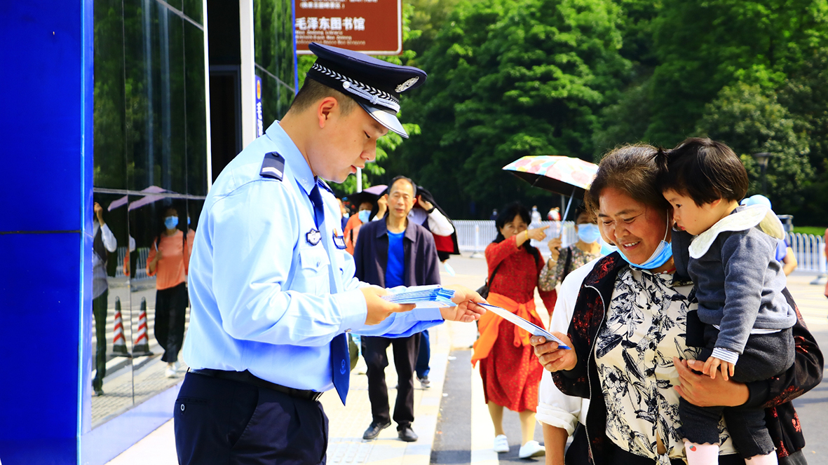 韶山?jīng)_派出所，民警向游客發(fā)放反詐宣傳單