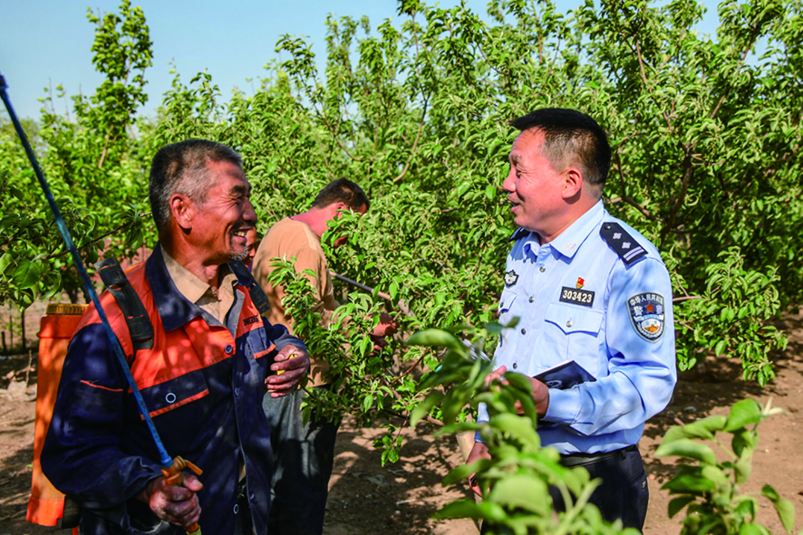 李華瑞（右）到果園走訪(fǎng)問(wèn)需