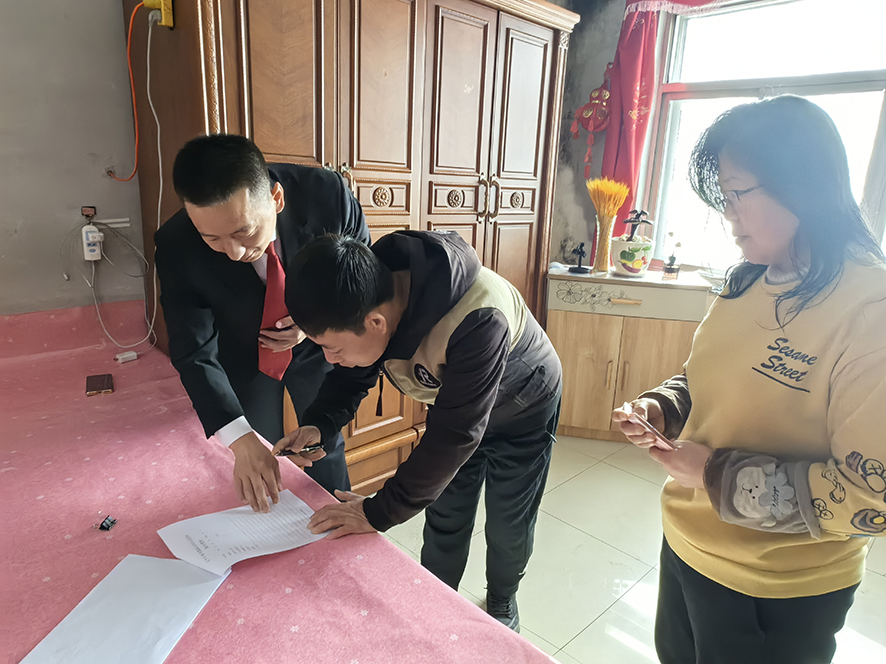 徐曉東（左一）指導(dǎo)孟某（中）在結(jié)案書上簽字