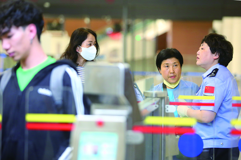 民警正在協(xié)助旅客進(jìn)行自助通關(guān),。