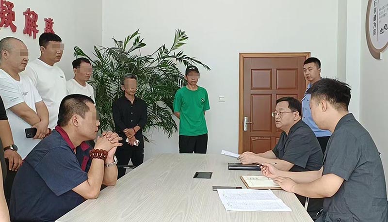 新民市法院執(zhí)行局局長王旌棘（右3）向農(nóng)民工們了解案情（所有不穿法服和警服的人，都需要馬賽克!）