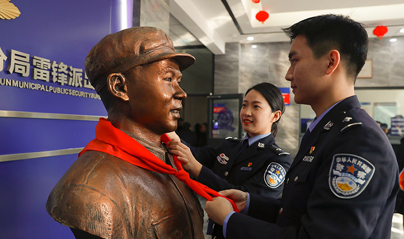 2024年3月5日,，撫順市公安局望花分局雷鋒派出所民警白靜（右）和長(zhǎng)沙市公安局雷鋒派出所民警韓政霖（左）共同為雷鋒塑像整理紅領(lǐng)巾。
