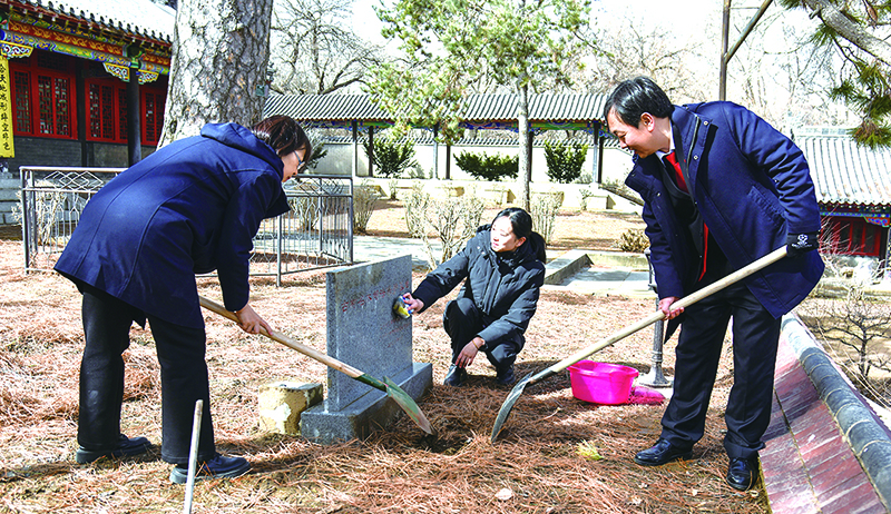 庭長賈宏斌（右一）,、副庭長史致鶴（左一）、法官助理李元旬為古樹填土澆水